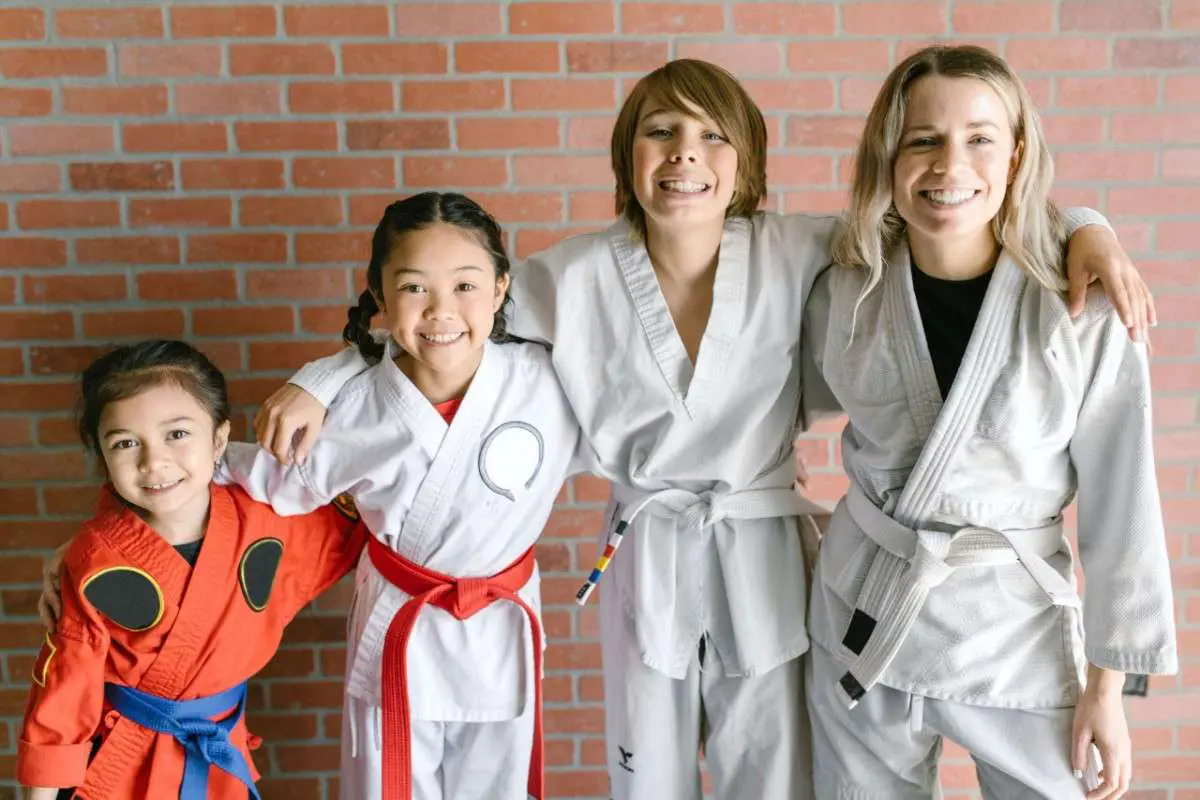 Group of students and instructors posing together after martial arts class