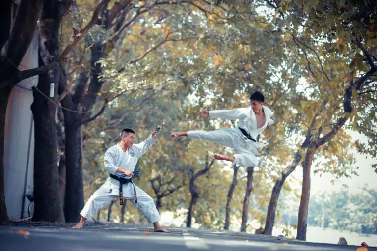 Martial arts demonstration with flying kick outdoors in training uniforms