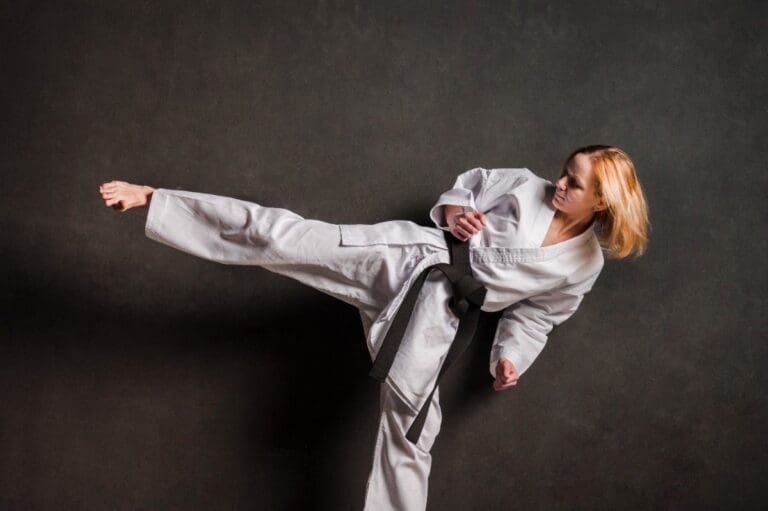 woman martial arts student performing a sidekick